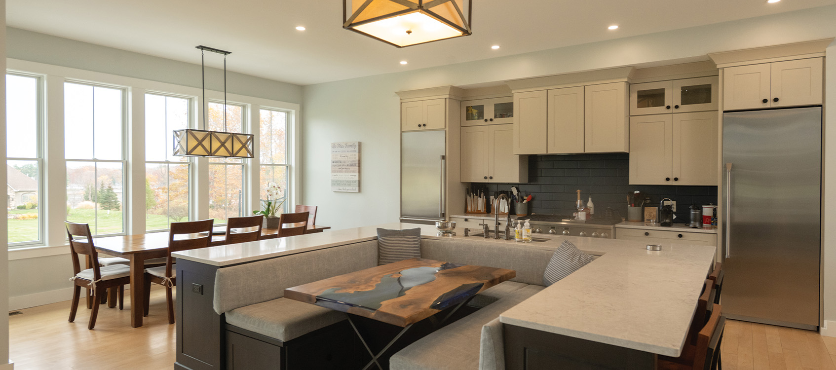 Kitchen and dining area with custom lighting by Woodstone Homes in Dover NH